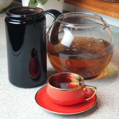 Słoik Saturm 1 litr wypełniony herbatą, dzbanek zaparzonej herbaty i filiżanka z herbatą